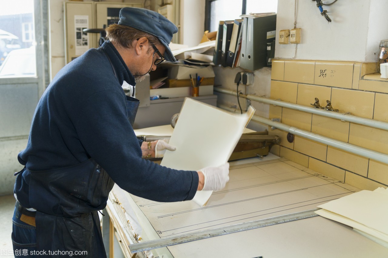 德国,巴伐利亚,成熟的人拿着装饰纸在印刷厂